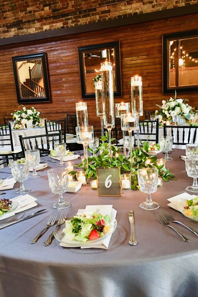 A Table with Gray Velvet Linens set with first course of salad for Reception at Palafox Wharf Waterfront in Pensacola, Florida - the beautiful Emerald Coast of Florida