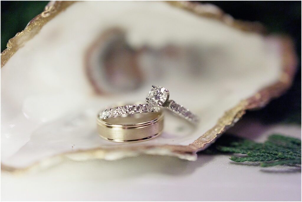 Pensacola venues pensacola fl showing bride and groom wedding rings and engagement ring in a gold oyster shell