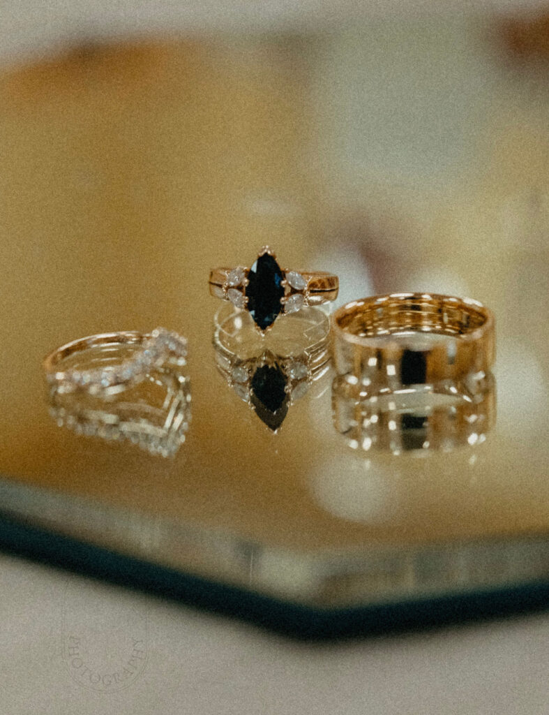 Palafox wharf waterfront showing beautiful sapphire engagement ring with gold groom’s band and bride’s wedding band at inexpensive wedding venues pensacola fl