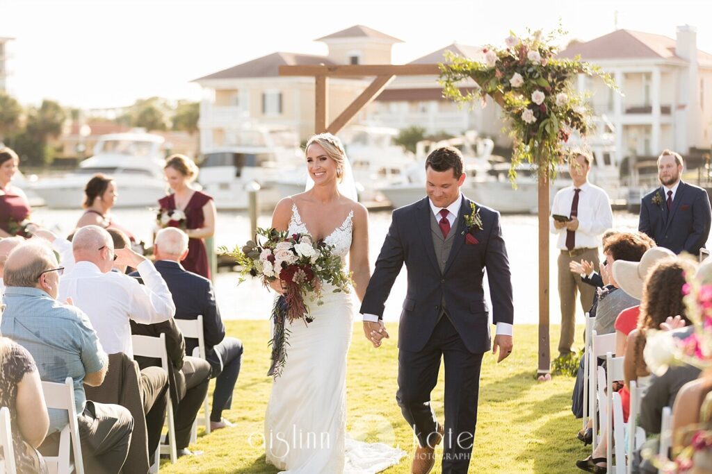 Kansas Destination Couple walking down the aisle after their Wedding Ceremony on the green at Palafox Wharf Waterfront on amazing Palafox Street in Pensacola, Florida (the Emerald Coast of Florida)