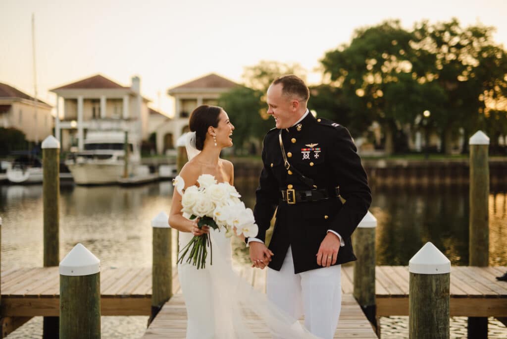 Destination wedding couple chatting about "WE DID IT!"  after their Wedding Ceremony and are strolling on Waterfront Dock at Palafox Wharf in Pensacola, Florida
