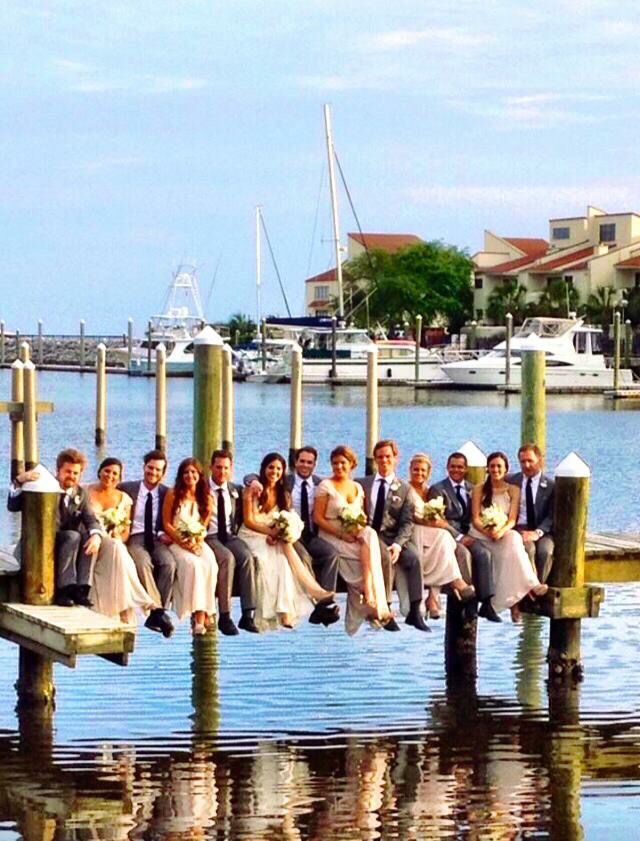 Venue - Sitting on the Pier are the Bride and Groom and Wedding Party at Palafox Wharf Waterfront Venue in Pensacola, Florida