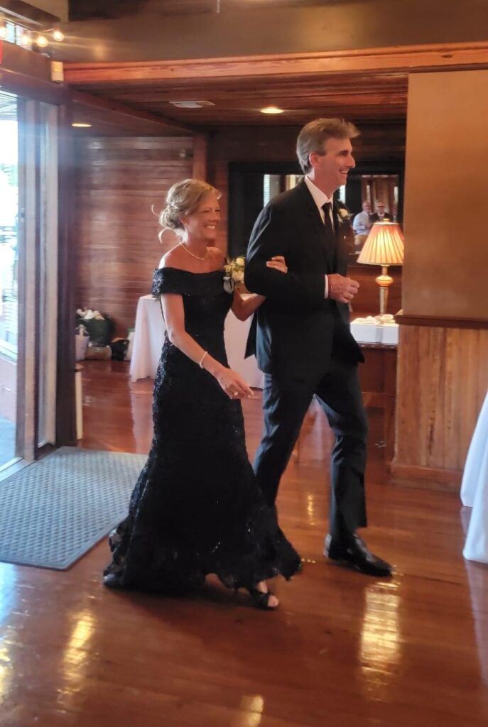 Parents of the Groom for an August Wedding with the Mother of the Groom dressed in a gorgeous navy blue gown and Father of the Groom in Black Suit  at https://617palafoxwharf.com/
https://thebellasera.com/
