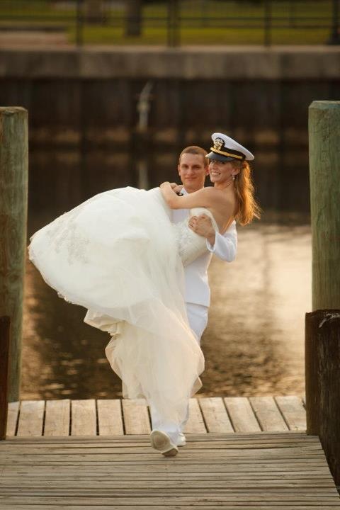 Military groom carrying smiling bride on Palafox Wharf Waterfront Dock, Pensacola, Florida . photo by East Hill Photo