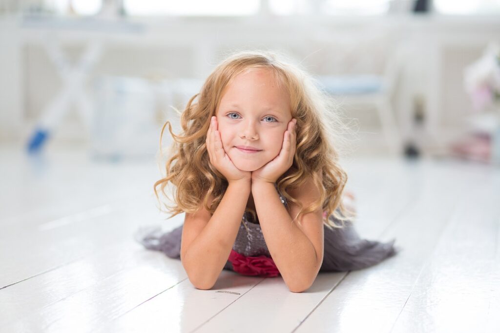 Blond hair smiling child on white floor with her hands placed on her face. https://tintopgin.com/ https://www.hightowerfalls.com/