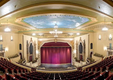 Elegant theater with red curtains and ornate ceiling, perfect date ideas in Pensacola.