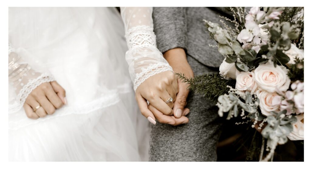 
Bride and Groom Just Married dressed in White Gown and he is wearing Gray Suit holding Blush Rose with Greenery Bouquet Near Destin Pensacola Florida 