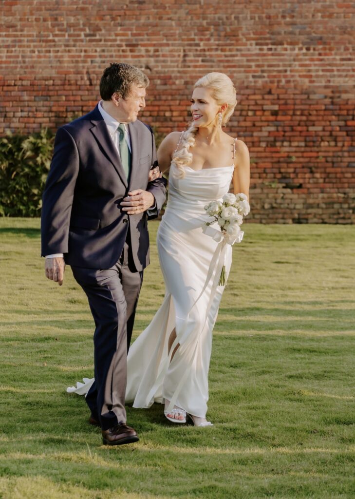 Bride walking down the aisle to her Groom at Palafox Wharf Waterfront Ceremony on the Green near Pensacola Florida events. Near Destin.