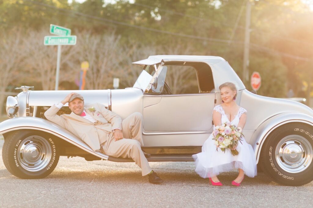 Near Destin Near Pensacola event center Palafox Wharf Waterfront Downtown Couple relaxing on luxury vehicle during photos at their Wedding at Palafox Wharf Waterfront