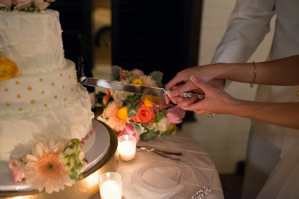 Event Wedding venue Pensacola near Destin Florida Cutting the Cake with florals and candle votives