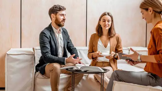 Guide to Prenuptial Agreements for Engaged Couples showing a bride and groom talking to a counselor about wether they need a pre-nup agreement

