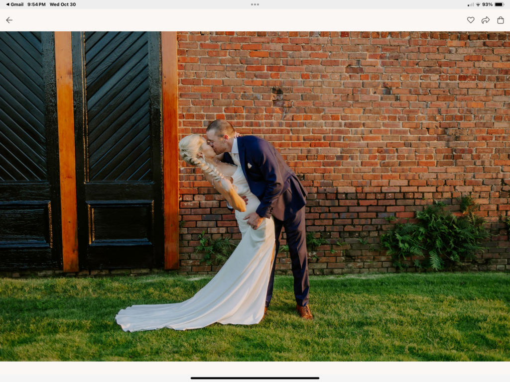 Pensacola Wedding Venue -showing Couple after Ceremony on The Green at Palafox Wharf Waterfront in front of the iconic black doors