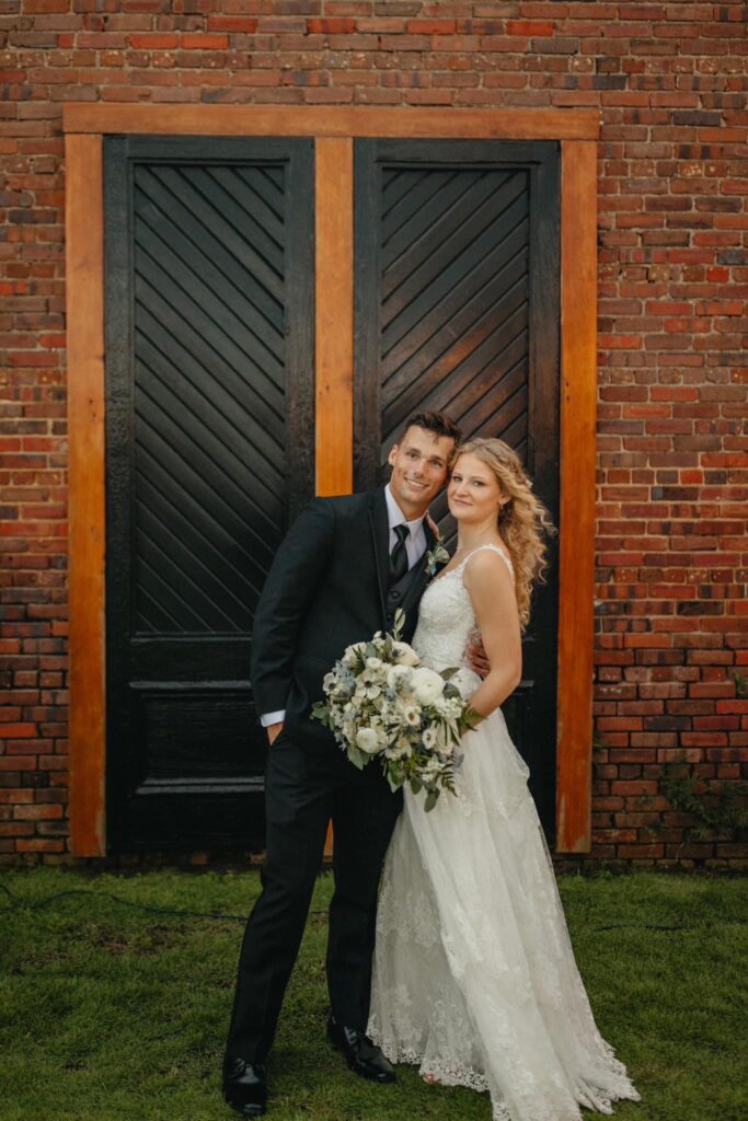 Posing in front of the black iconic double doors as man and wife at Palafox Wharf Waterfront Venue