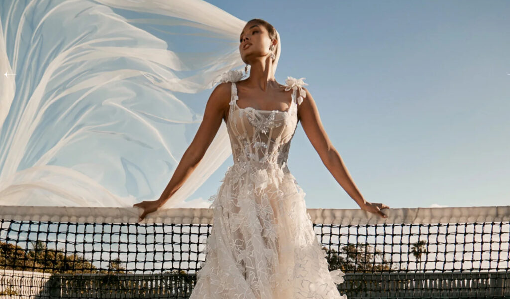 Wedding Dates Available at Pensacola Wedding Venue showing  Corset style wedding dress with elaborate embroidery and visible boning which emphasizes the corset like structure and the vintage appeal and in this photo the florals are gorgeous on this dress.