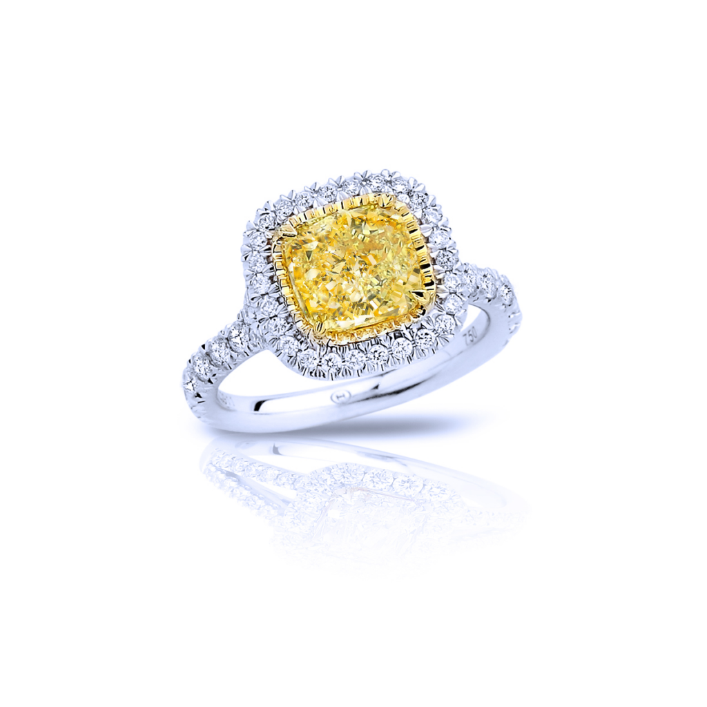 Close-up of a yellow diamond engagement ring with white diamonds and platinum band