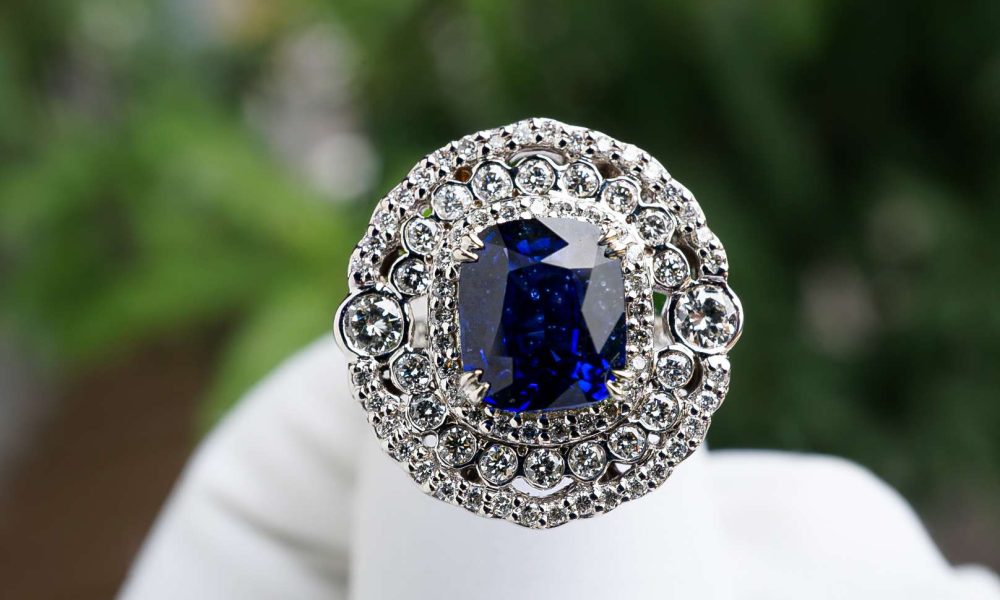 Beautiful ring with blue stone and white diamonds with a green background
