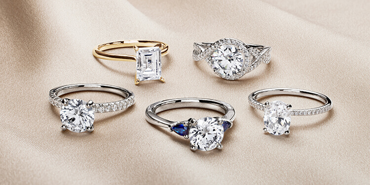 Various diamond rings with white diamonds and one with 2 blue shaphires.  