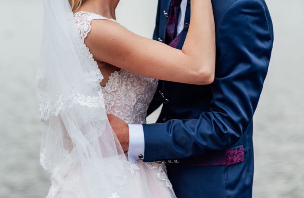 Pensacola Wedding Venue showing bride in white dress and groom in navy blue with floral pocket flap