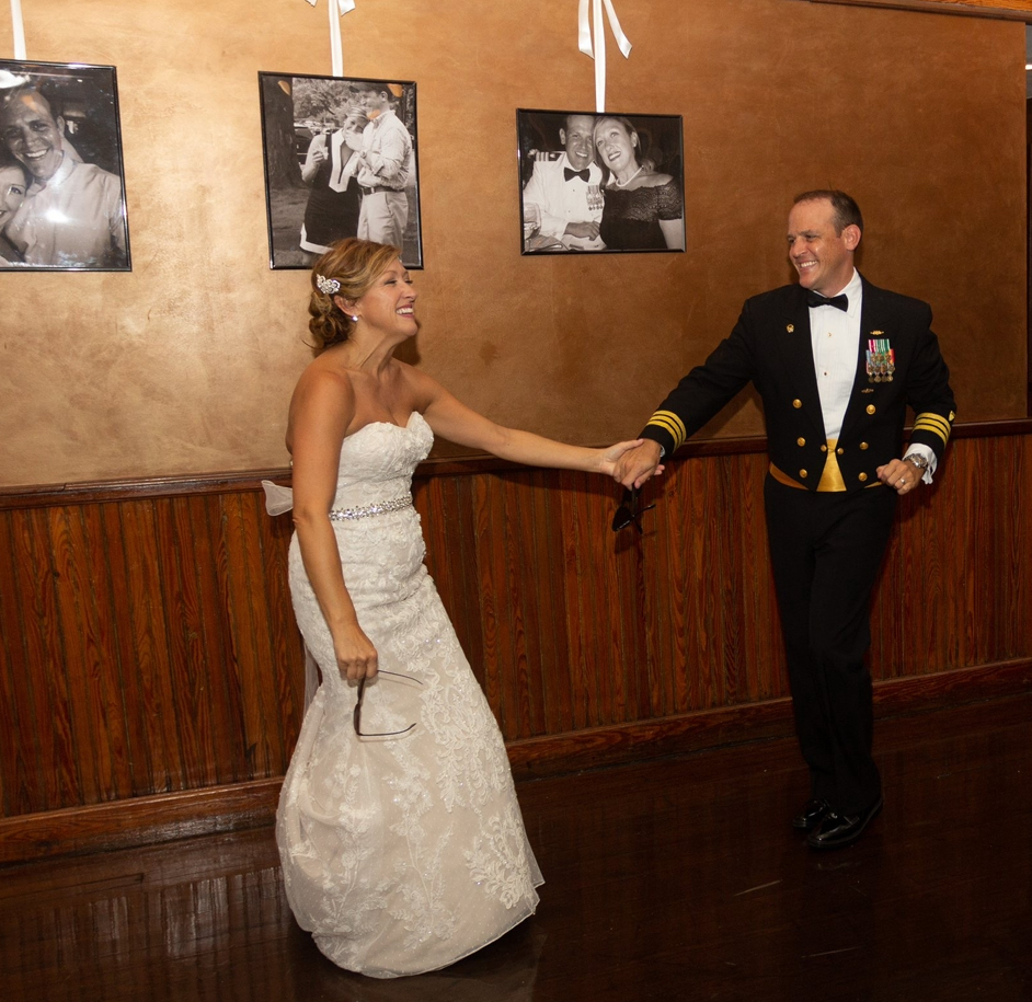 Wedding Venues Pensacola showing bride and commander of the coast guard Mobile with enlarged photos in the background on the copper wall