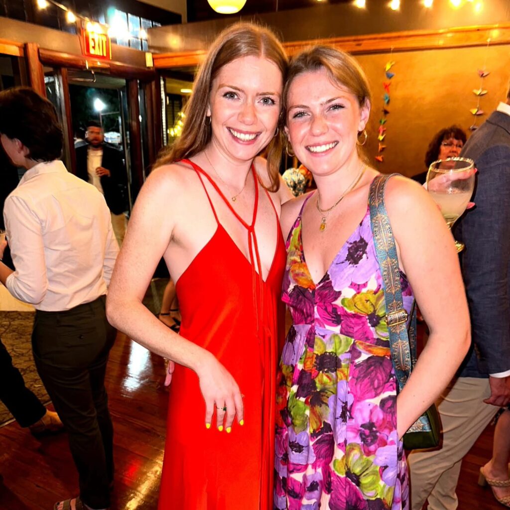 Wedding Venue Pensacola showing guests at a Wedding Celebration for their fellow doctors having been married Showing 2 pretty guests with one in a red dress and another in a floral purple dress