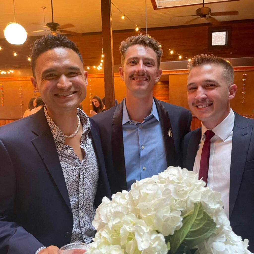 Wedding Venues Pensacola showing guests at a Wedding Celebration for their fellow doctors having been married showing 3 guests all in dark blue suits and all smiling