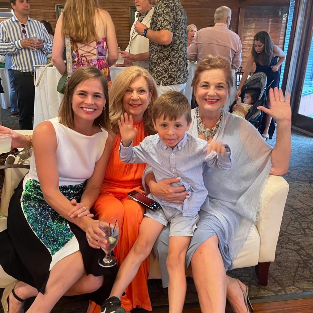 Wedding Venue Pensacola showing guests at a Wedding Celebration for their fellow doctors having been married With guests moving around and in the foreground two older women with their grandchildren and in the background more fellow guests from work 