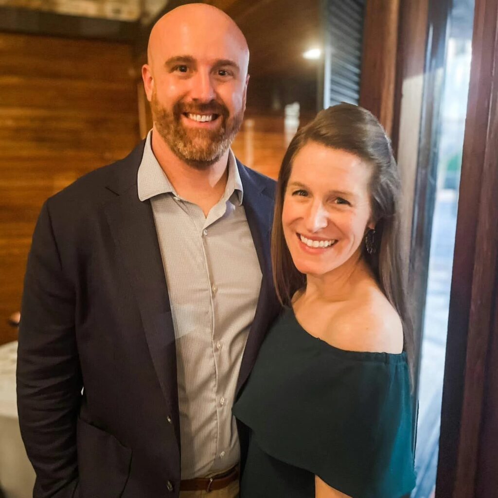 Wedding Venue Pensacola showing guests at a Wedding Celebration for their fellow doctors having been married and she is in a green dress and he is in a blue suit jacket and gray shirt 