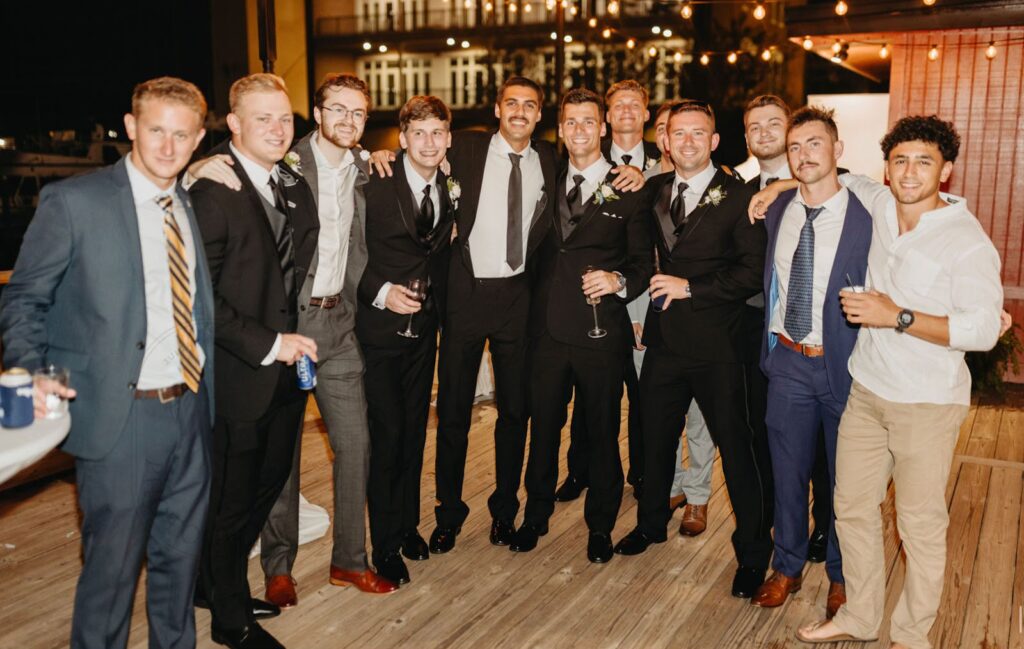 A diverse group of men in formal suits and ties, standing side by side, showcasing camaraderie and professionalism.
