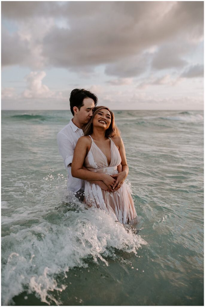 Romance in the water at the beginning of a Sunset after a beach proposal at Henderson Beach.