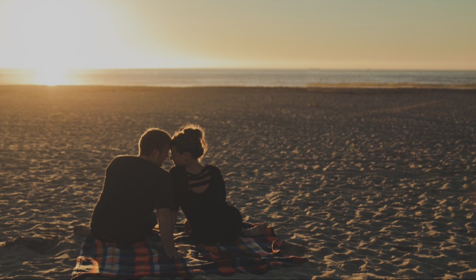 Cozy Couple sitting down on the beach at Perdido Key.