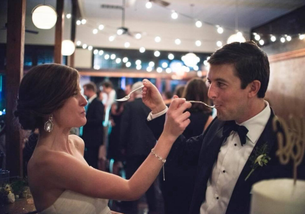 wedding venues pensacola fl with bride and groom tasting their cake inside palafox wharf waterfront wedding venue
