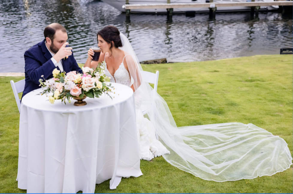 Wedding venues pensacola showing one of the waterfront weddings with the bride and groom enjoying a cocktail near the water
