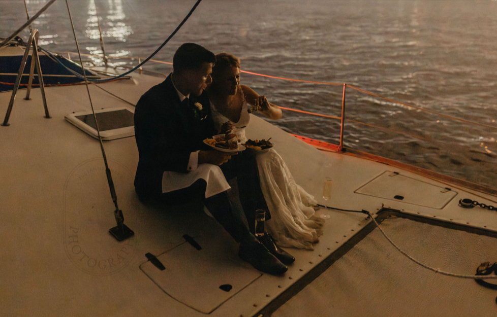wedding venue pensacola with bride and groom enjoying a bite to eat and drink on a little boat ride on the water at Palafox Wharf Waterfront Wedding Venue