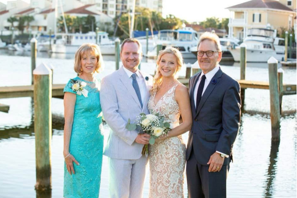 Palafox wharf waterfront wedding venue with the family and bride and groom in front of the water on Palafox Street the heart of Pensacola