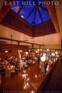 This Wedding Venue Pensacola’s East Hill's photo of Palafox Wharf Waterfront's interior showing huge sky lights with glorious evening sun shining through with that beautiful blue light of the evening - dreamy