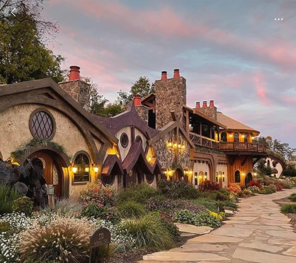 Romantic road trips for newly engaged couples featuring wedding venues like Palafox Wharf Waterfront Wedding Venue, showcasing a charming, fairy-tale-style building with a scenic pathway at sunset.