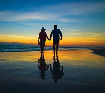 romantic date ideas in Destin Fl one of Pensacola Florida whimsical wedding venues this couple walking during sunset or sunrise on the beach in shallow water
