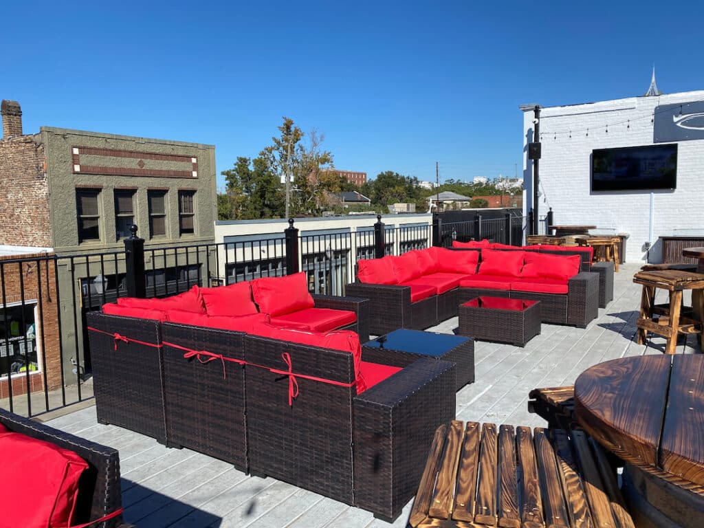 Stunning rooftop with red seating at a top eatery place Mobile, AL, perfect for outdoor relaxation after viewing wedding places in Pensacola fl
