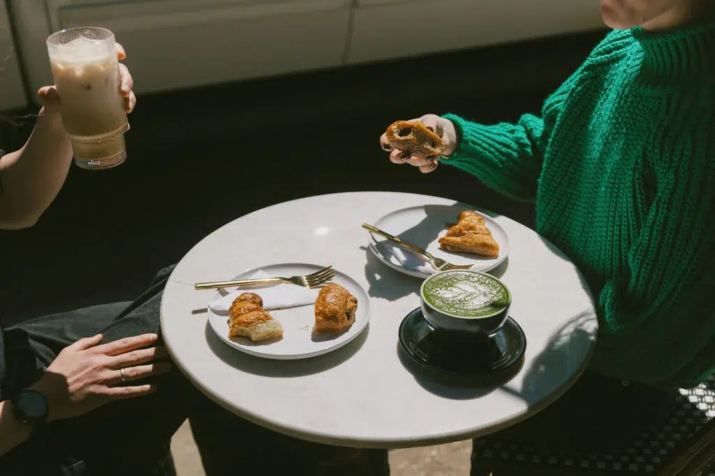 Enjoying croissants at an elegant café, perfect for a Mobile brunch after view Pensacola wedding venues the previous day.
