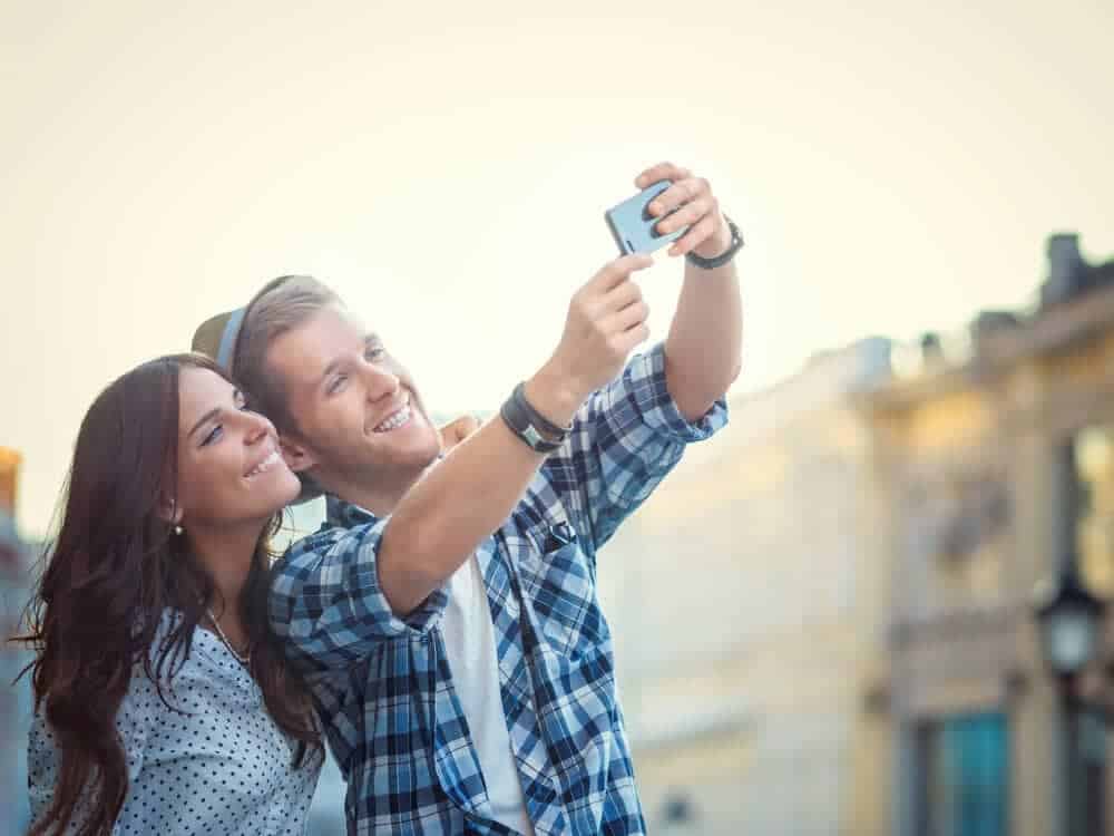Smiling couple selfie in downtown Mobile: man in plaid, woman in polka-dot—ideal pre-wedding date vibe for couples. 52 Amazing Date Ideas in Mobile. 

