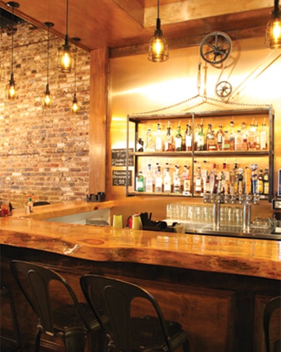 Dumbwaiter’s bar with handcrafted bar top with interesting light from the ceiling which is a great date idea in mobile 