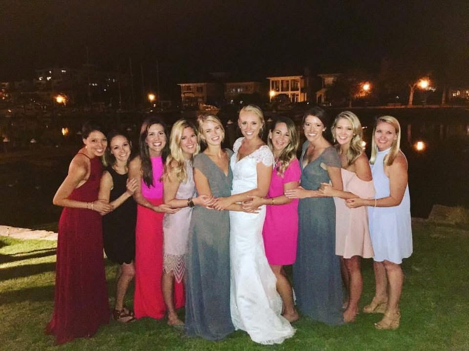 wedding places in pensacola fl with bridal party posing by water.