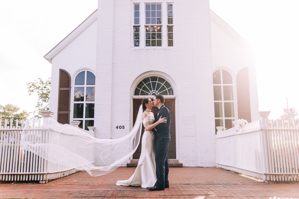 wedding places in pensacola fl with couple embracing in front of church.